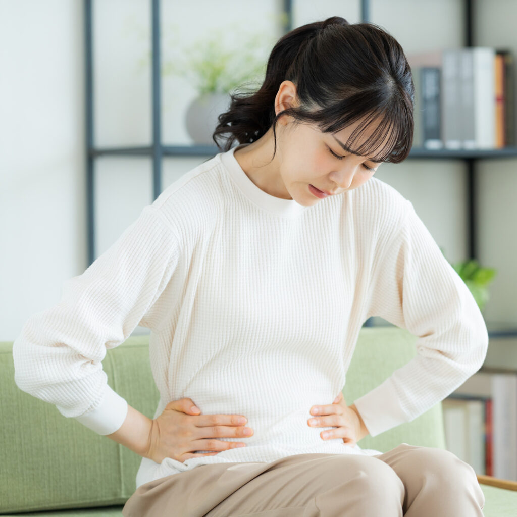 腹痛に悩んでいる女性